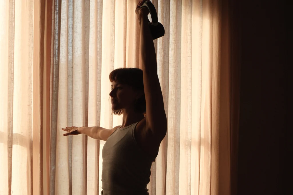 An instructor lifting a kettlebell in a strength and mobility class
